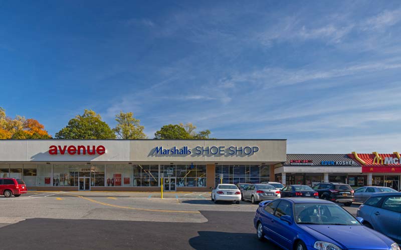 Central Plaza storefronts behind a broad parking lot on Central Avenue